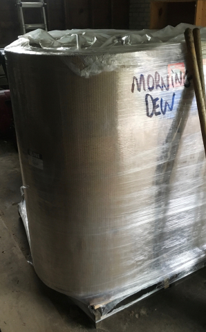 shrink wrapped rolls of cardboard about three feet tall